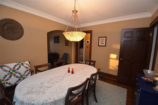 dining space with dark hardwood / wood-style flooring and ornamental molding