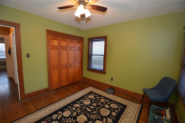 bedroom featuring ceiling fan, dark hardwood / wood-style flooring, and a closet