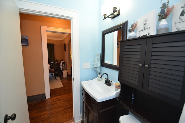 bathroom with vanity, wood-type flooring, and ornamental molding