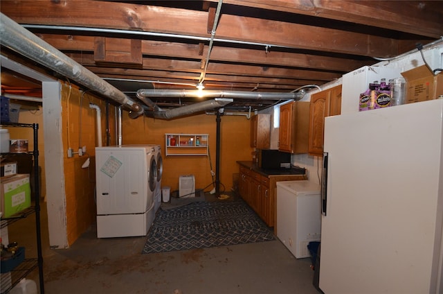 basement with white refrigerator, fridge, and washing machine and clothes dryer