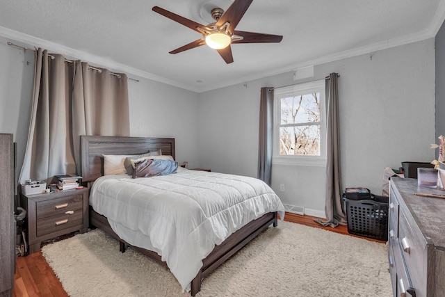 bedroom featuring ceiling fan, crown molding, and light hardwood / wood-style floors