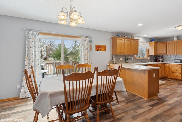 dining space with hardwood / wood-style flooring, sink, and an inviting chandelier