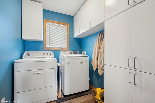 clothes washing area with cabinets and washer and dryer