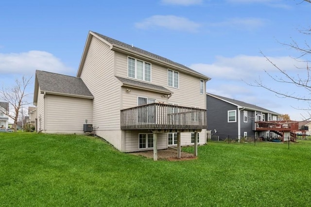 back of property with a yard, a deck, and central air condition unit