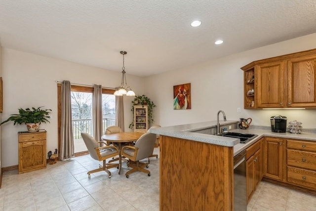 kitchen with sink, hanging light fixtures, stainless steel dishwasher, kitchen peninsula, and a textured ceiling