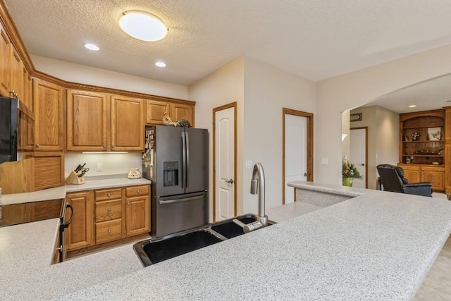 kitchen featuring stainless steel fridge and a textured ceiling