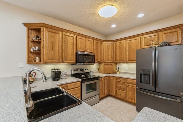 kitchen featuring a textured ceiling, sink, and stainless steel appliances