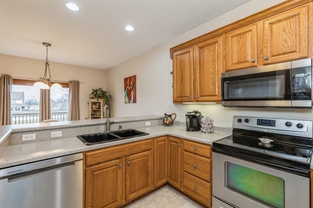 kitchen with sink, kitchen peninsula, stainless steel appliances, and hanging light fixtures