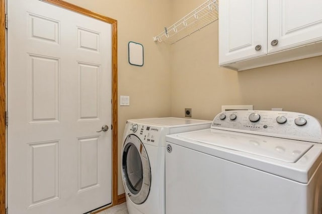 laundry room with washing machine and dryer and cabinets