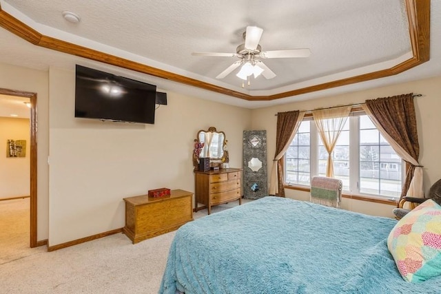 bedroom featuring ceiling fan, a raised ceiling, ornamental molding, and light carpet