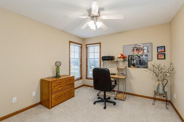 carpeted office space featuring ceiling fan and a textured ceiling