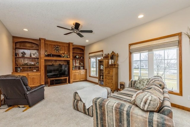 carpeted living room featuring ceiling fan and a textured ceiling