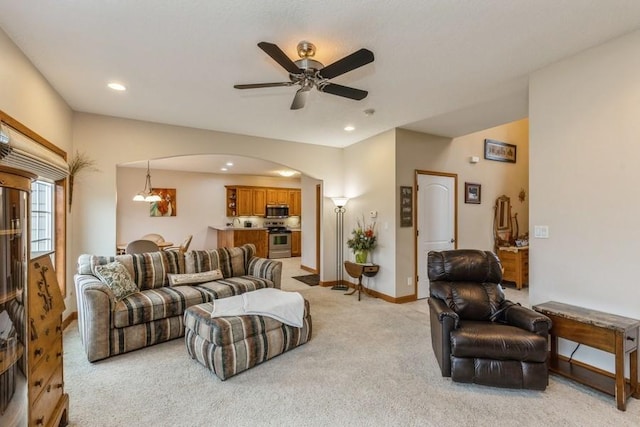 carpeted living room with ceiling fan