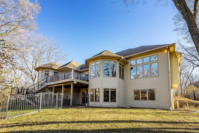 back of property with a sunroom, a deck, and a yard