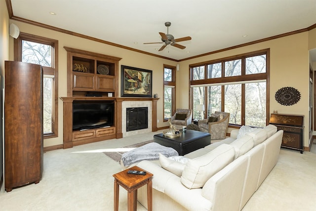 carpeted living room with a fireplace, a wealth of natural light, ornamental molding, and ceiling fan