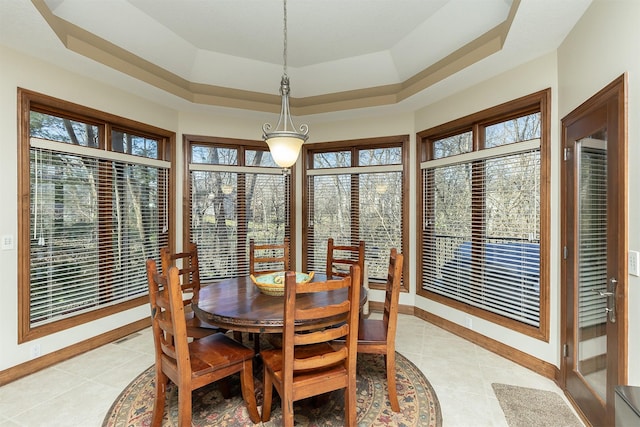 tiled dining room featuring a raised ceiling