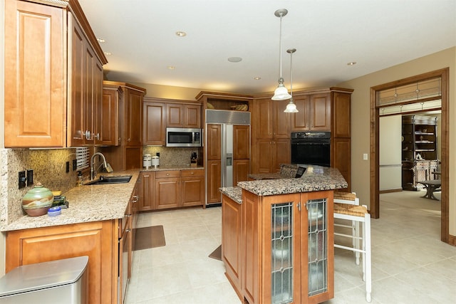 kitchen with a kitchen island, sink, decorative light fixtures, paneled built in fridge, and black oven