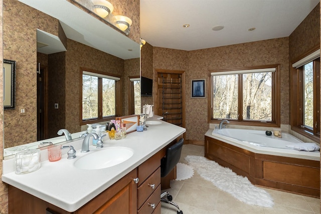 bathroom featuring tile patterned floors, a washtub, a healthy amount of sunlight, and vanity