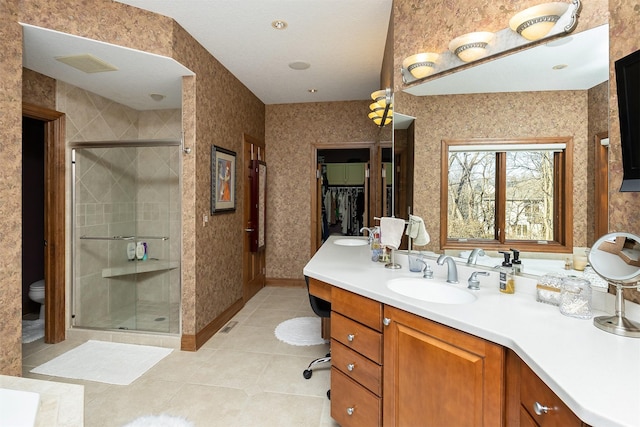 bathroom featuring tile patterned floors, a shower with door, vanity, and toilet