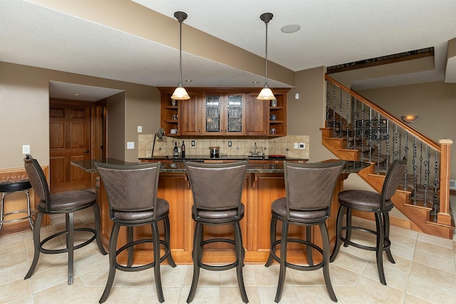 bar featuring decorative backsplash and decorative light fixtures