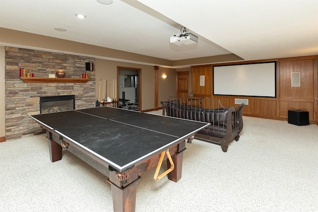 game room featuring wood walls and a fireplace