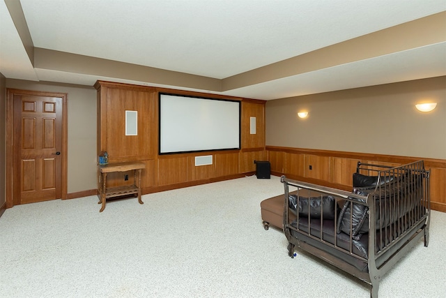 carpeted cinema featuring wood walls