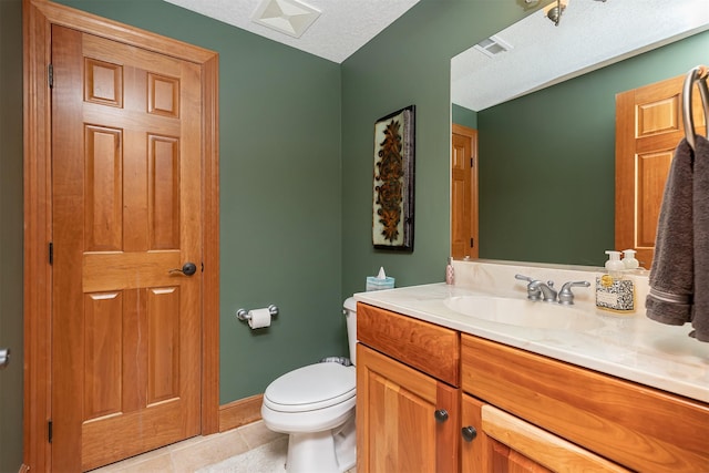 bathroom with tile patterned flooring, vanity, toilet, and a textured ceiling