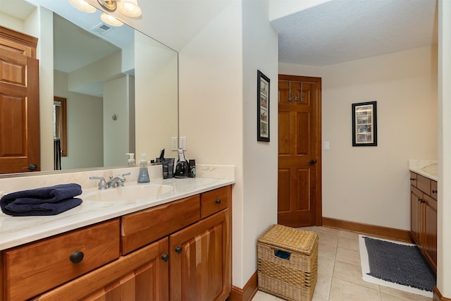 bathroom featuring tile patterned flooring, vanity, and a textured ceiling