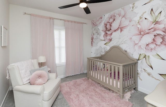 carpeted bedroom with a crib, multiple windows, and ceiling fan