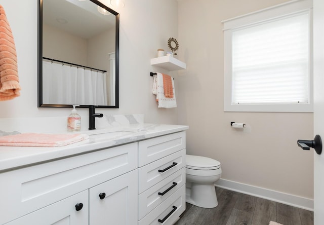 bathroom with hardwood / wood-style floors, vanity, and toilet