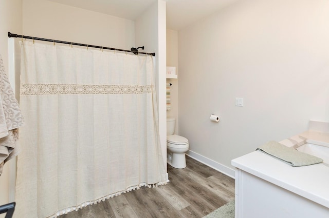 bathroom with toilet, vanity, and hardwood / wood-style flooring