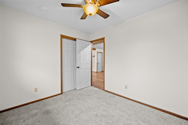 unfurnished bedroom featuring ceiling fan, a closet, and light carpet