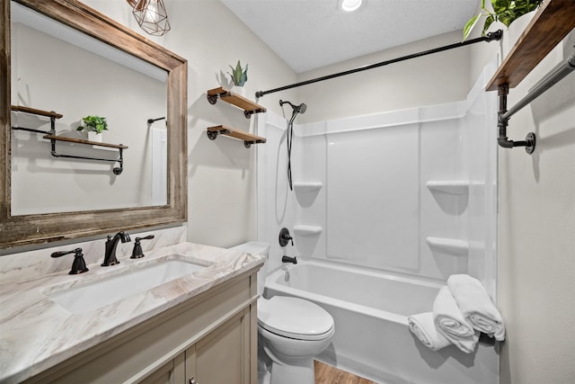 full bathroom featuring wood-type flooring, vanity, toilet, tub / shower combination, and a textured ceiling