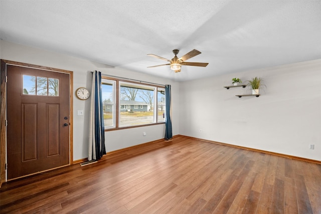 foyer featuring wood-type flooring, a textured ceiling, and ceiling fan