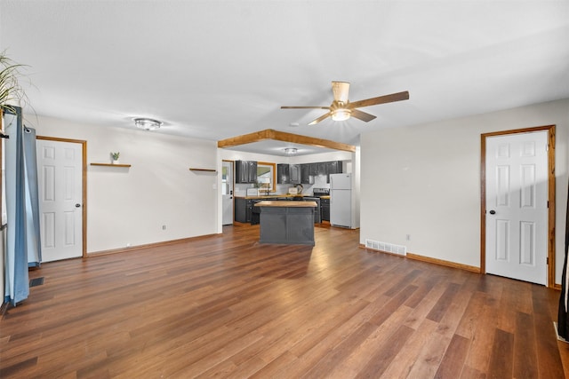 unfurnished living room with dark wood-type flooring and ceiling fan