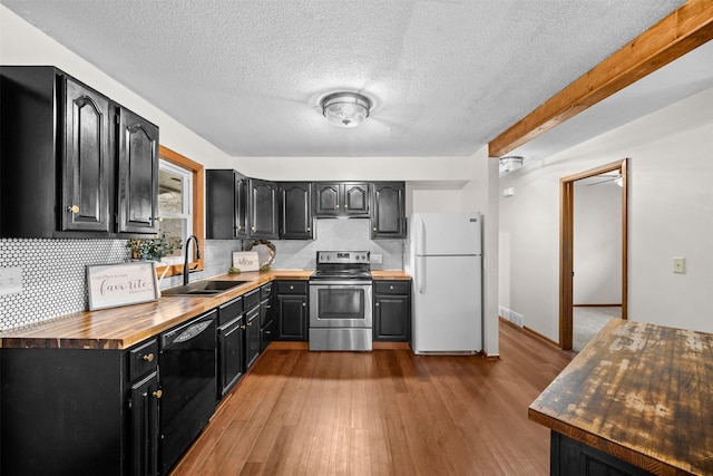 kitchen featuring wood counters, sink, black dishwasher, stainless steel range with electric cooktop, and white fridge