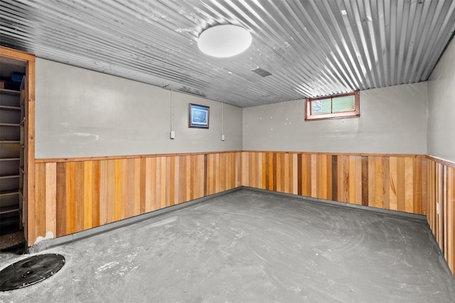 basement featuring wooden walls