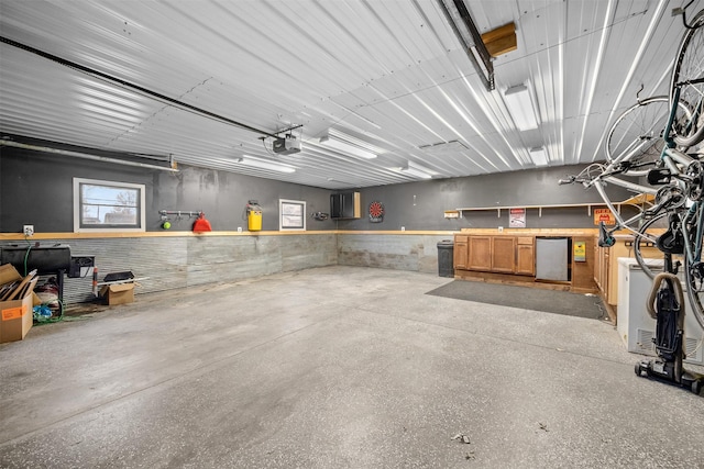 garage featuring a garage door opener, fridge, and a workshop area