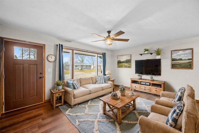 living room with ceiling fan and dark wood-type flooring