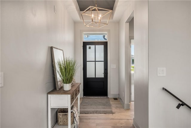 entryway featuring light wood-type flooring and an inviting chandelier