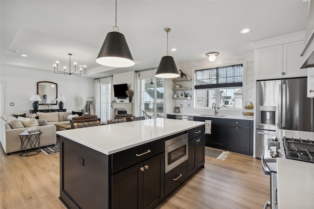 kitchen with white cabinetry, pendant lighting, a center island, and stainless steel appliances