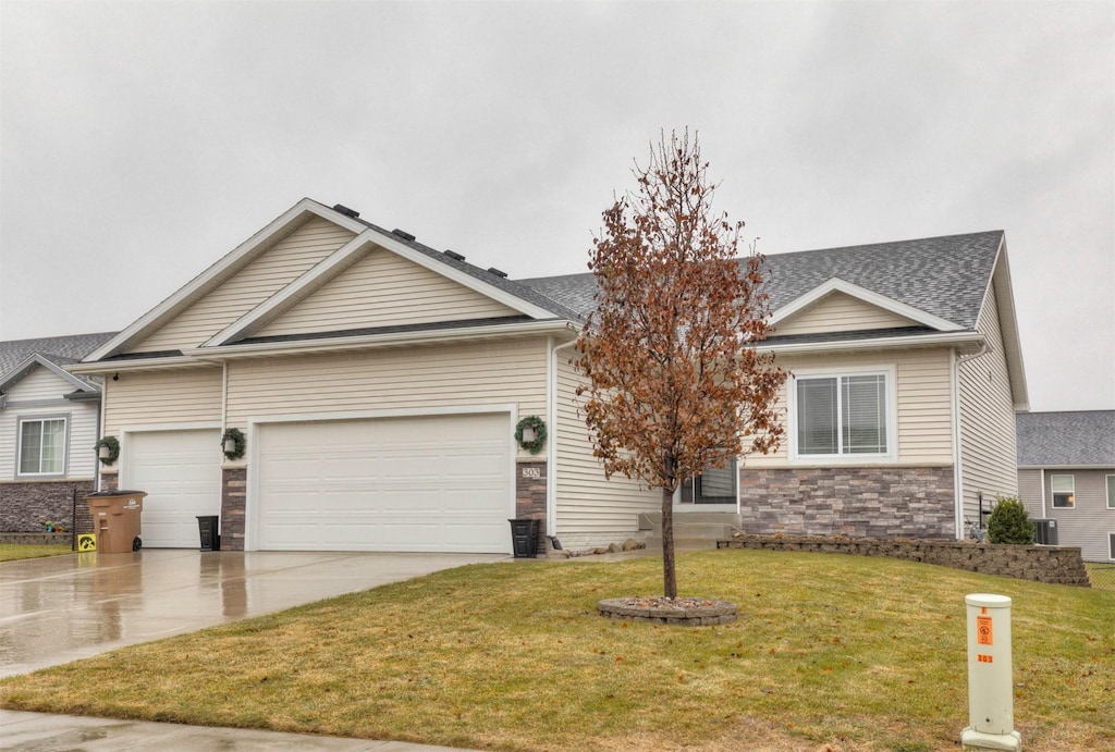 view of front of house with a front yard, a garage, and central air condition unit