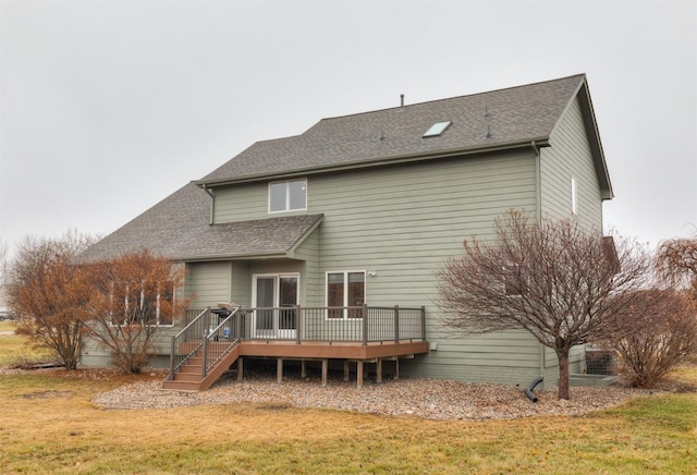 rear view of house featuring a deck and a lawn