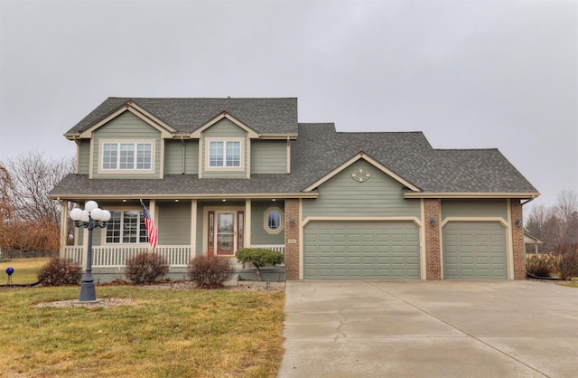 view of front of house with covered porch, a garage, and a front lawn