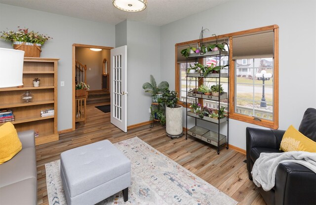 living area featuring hardwood / wood-style floors, a textured ceiling, and french doors