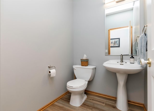 bathroom with hardwood / wood-style flooring and toilet