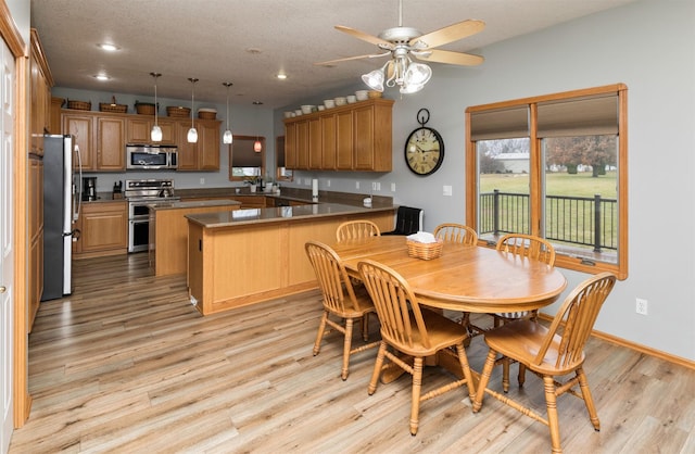 dining room featuring ceiling fan, light hardwood / wood-style flooring, and a textured ceiling