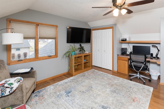 office space with lofted ceiling, a textured ceiling, ceiling fan, and light wood-type flooring