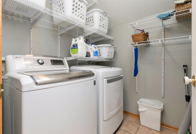 washroom featuring light tile patterned floors, independent washer and dryer, and a textured ceiling