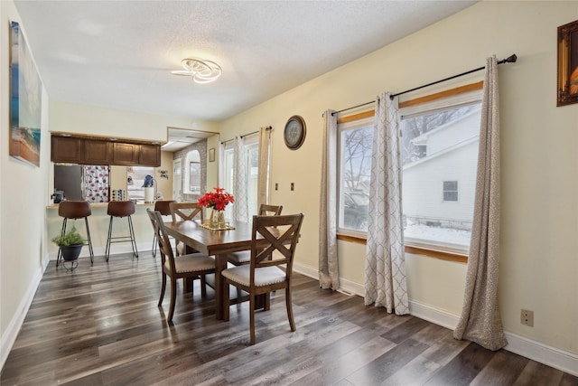 dining area featuring dark hardwood / wood-style flooring, plenty of natural light, and a textured ceiling